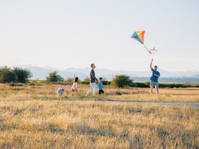 parents are flying a kite with a child