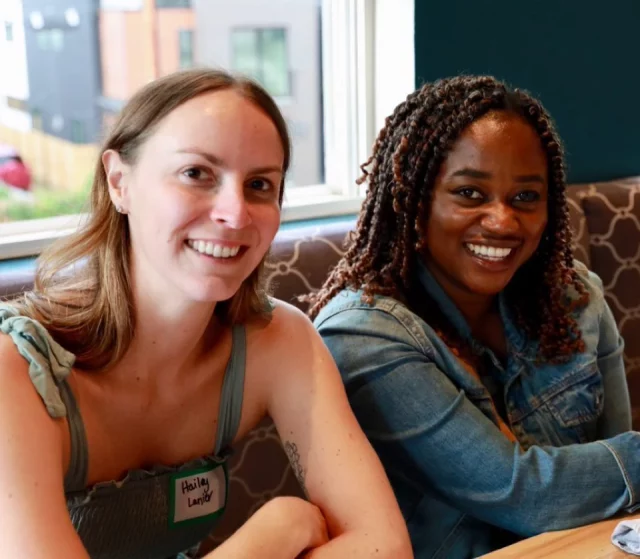 two women who work at AbsenceSoft at a table smiling