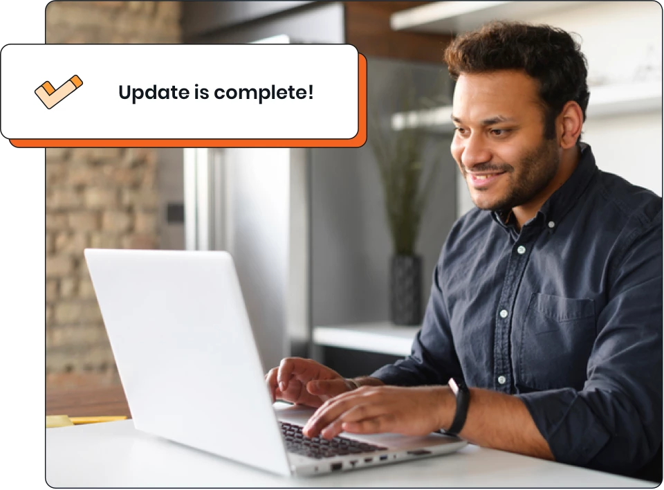 Man sitting at desk with laptop with text overlay, "update is complete!"